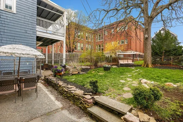 a view of a chairs and a table in backyard of the house