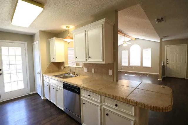 a bathroom with a granite countertop sink and a mirror