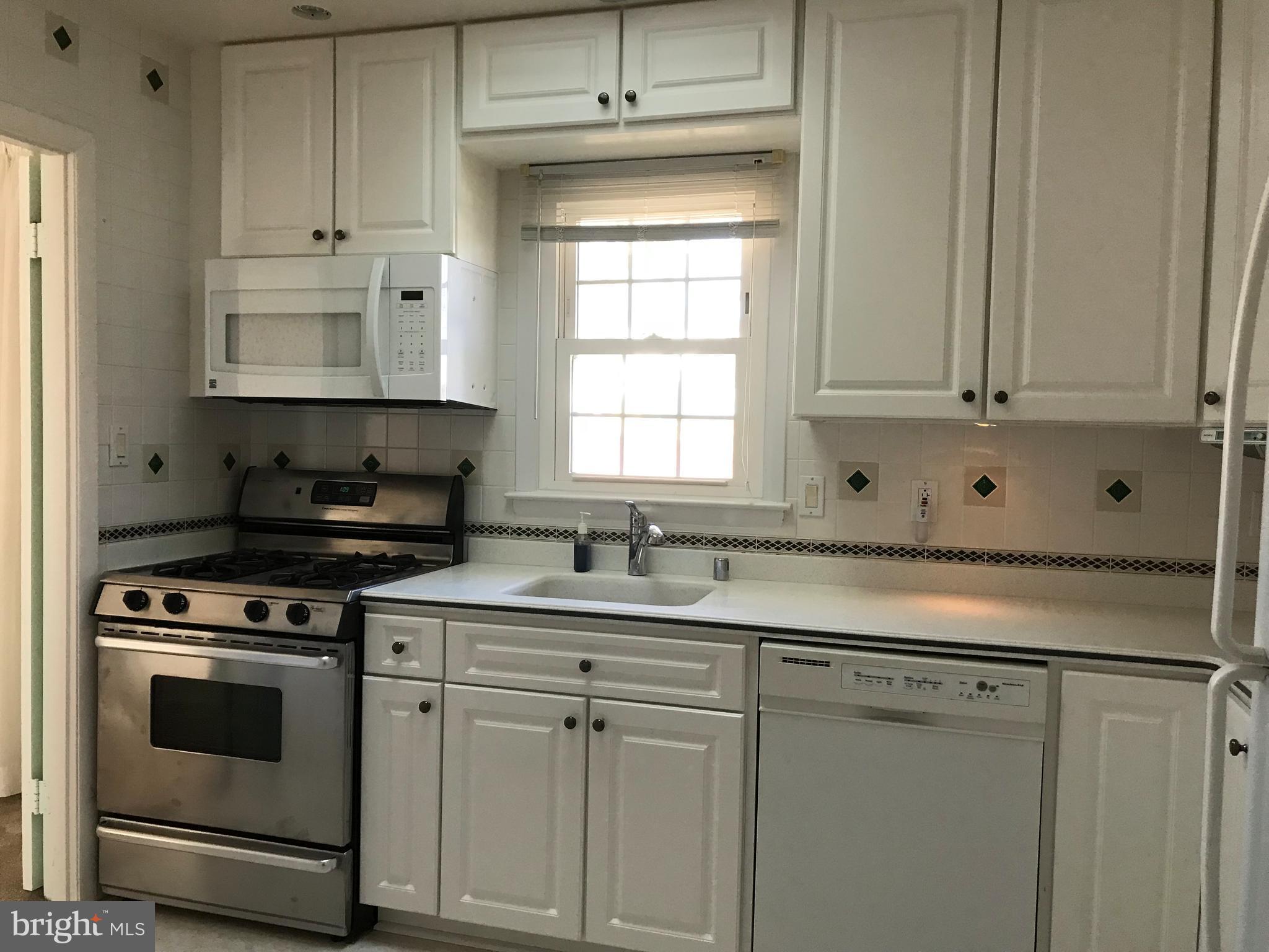 8411 Coco Road Baltimore, MD 21237 - Photo 4 of 23 a kitchen with white cabinets and white appliances