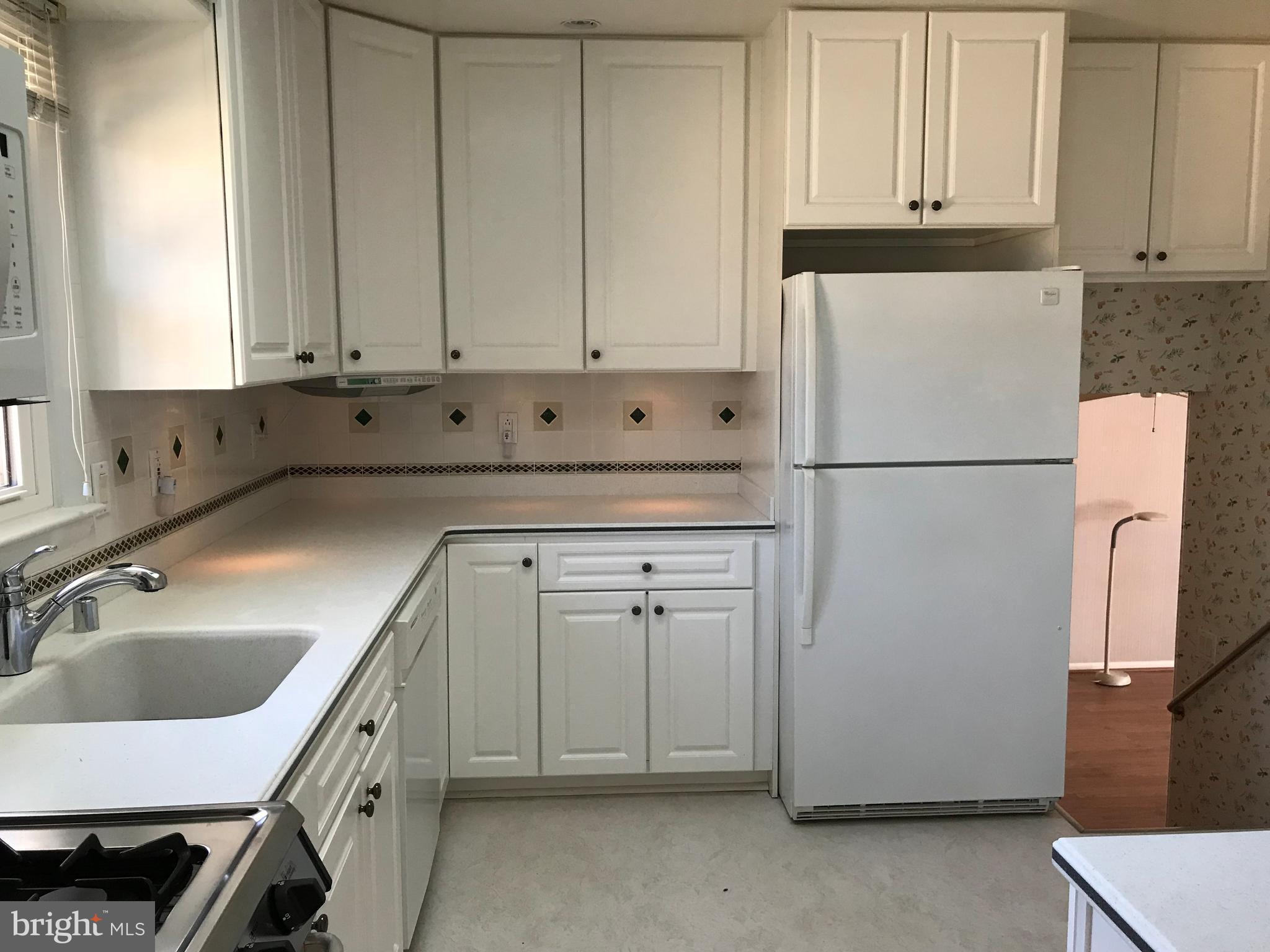 8411 Coco Road Baltimore, MD 21237 - Photo 5 of 23 a kitchen with white cabinets and white appliances