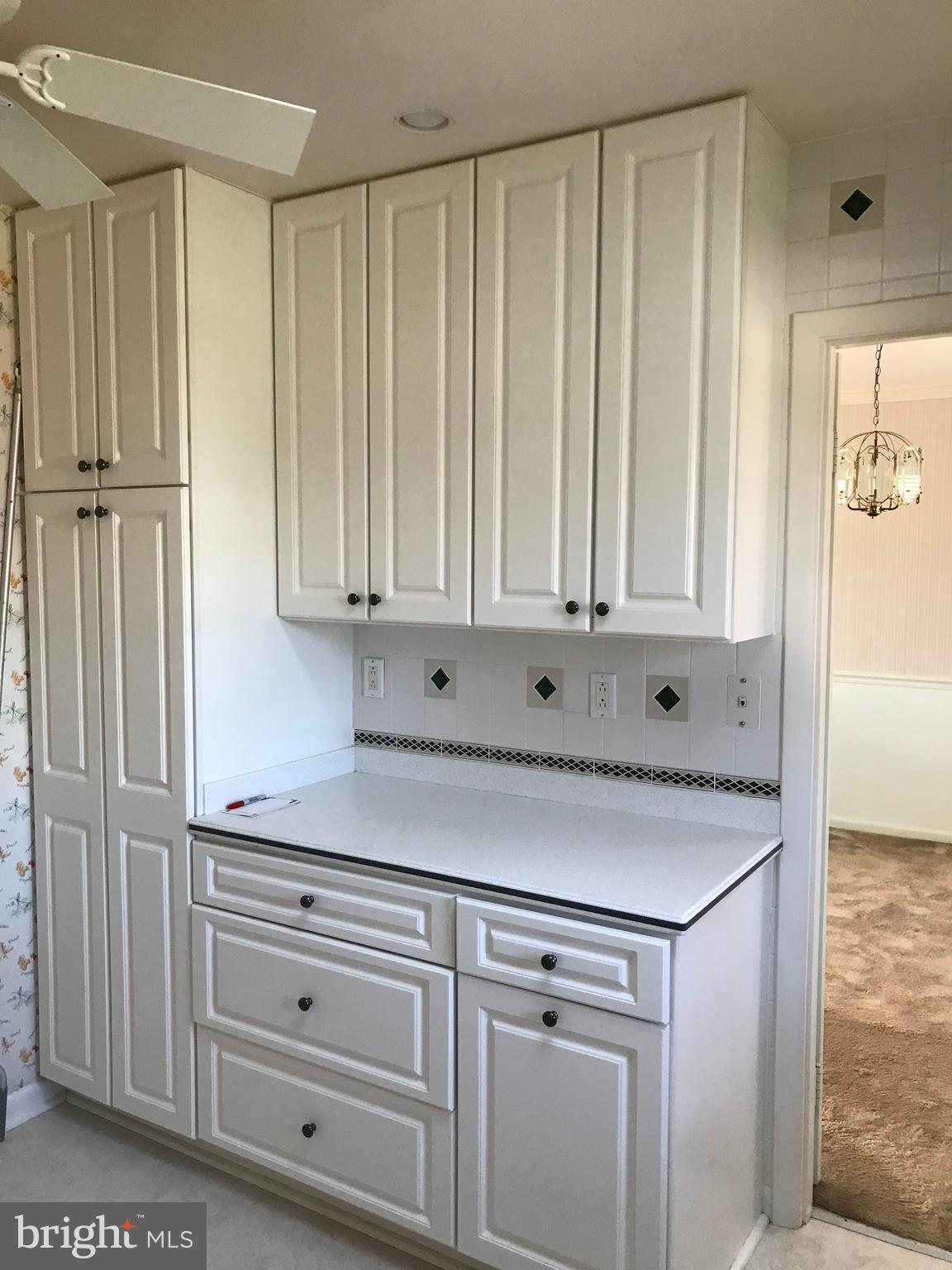 8411 Coco Road Baltimore, MD 21237 - Photo 6 of 23 a kitchen with white cabinets and a refrigerator