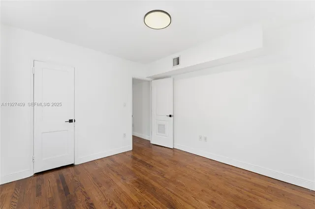 a view of a room with wooden floor and white walls