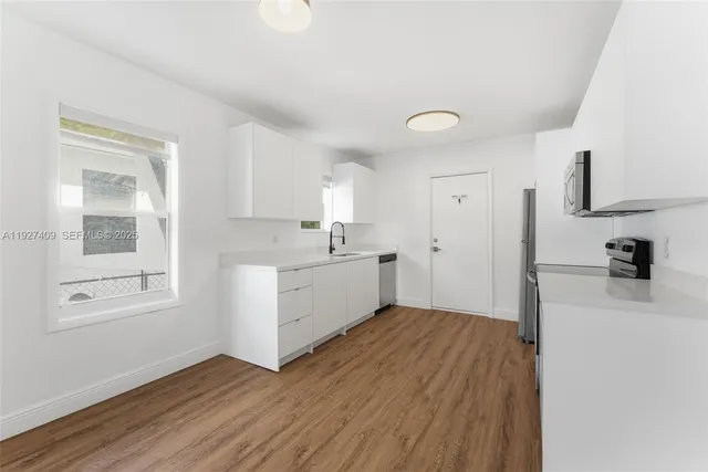 a view of a kitchen with wooden floor and a sink