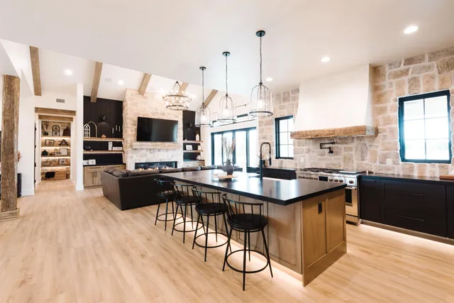 a kitchen with stainless steel appliances kitchen island granite countertop a stove and more cabinets