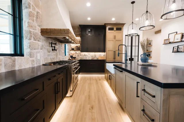 a large kitchen with stainless steel appliances kitchen island granite countertop a large stove a sink dishwasher and cabinets with wooden floor