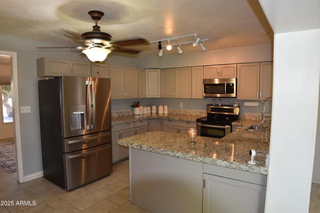 a kitchen with a refrigerator and a chandelier