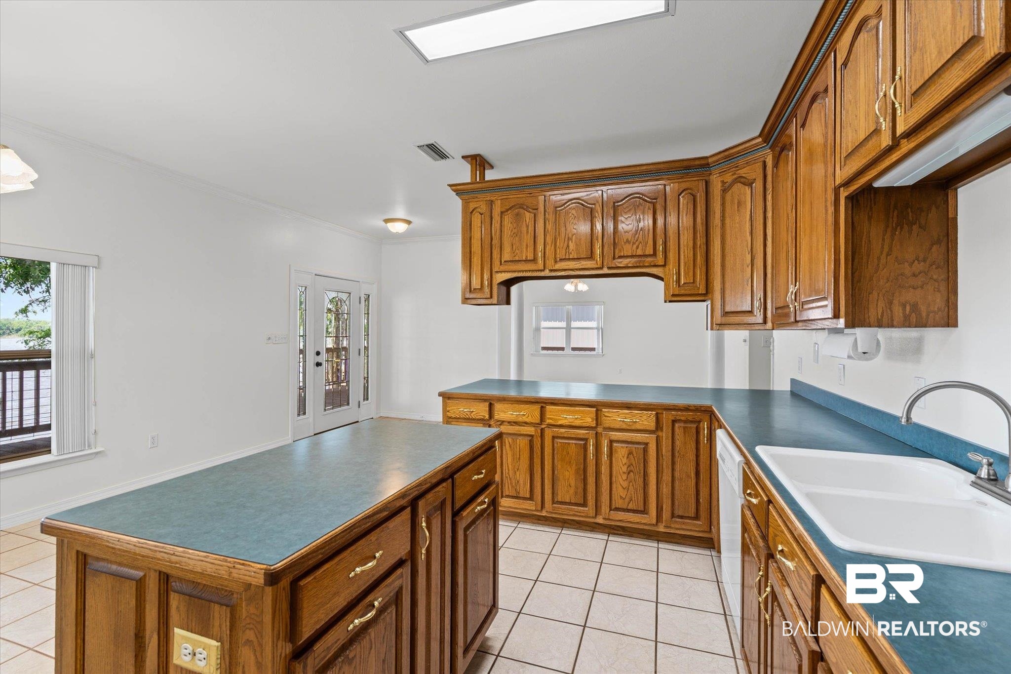 41923 Bayou Road Bay Minette, AL 36507 - Photo 9 of 35 Kitchen featuring wood cabinetry with brass hardware, a central island, and blue countertops