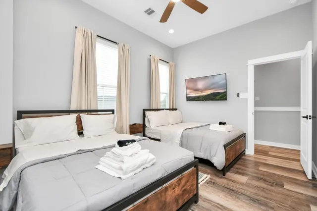 a bedroom with two beds and a large window