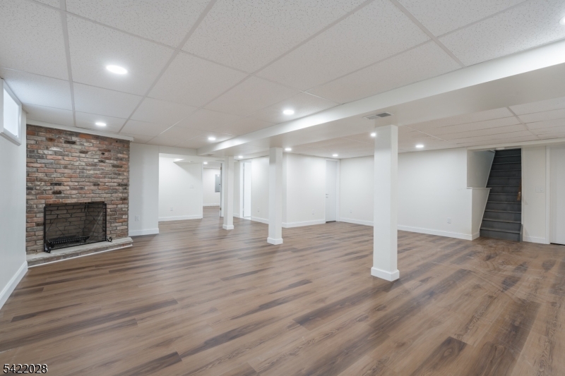 6 Windsor Way Berkeley Heights, NJ 07922 - Photo 31 of 36 a view of an empty room with wooden floor fire place and kitchen view