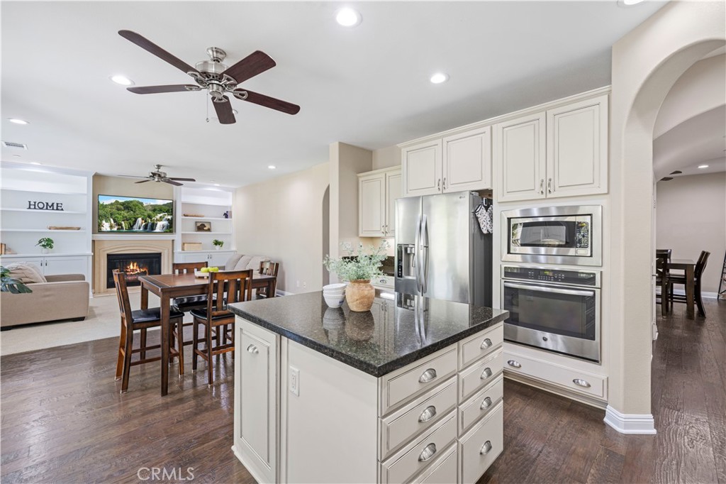 28319 Chisel Court Valencia, CA 91354 - Photo 12 of 74 a kitchen with granite countertop a refrigerator a stove a dining table and chairs with wooden floor