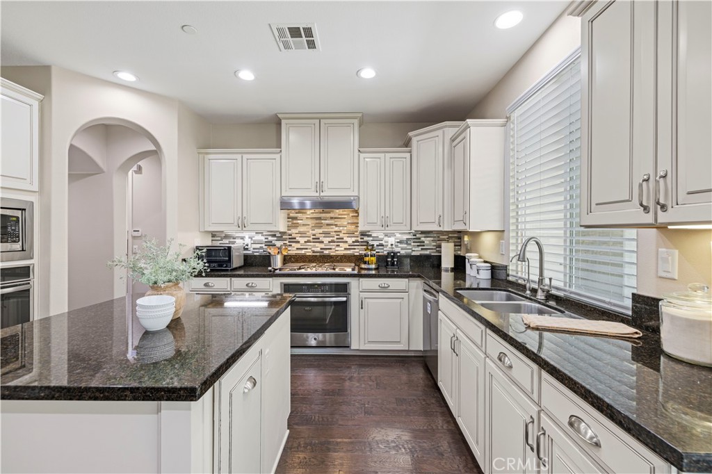 28319 Chisel Court Valencia, CA 91354 - Photo 9 of 74 a kitchen with stainless steel appliances granite countertop a sink stove and cabinets