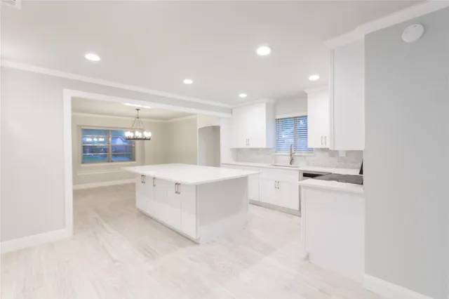 a large white kitchen with cabinets