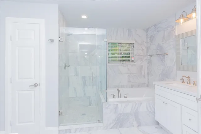 a bathroom with a bathtub shower and sink