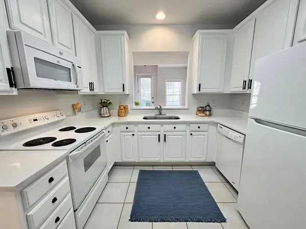 a kitchen with white cabinets sink and white appliances