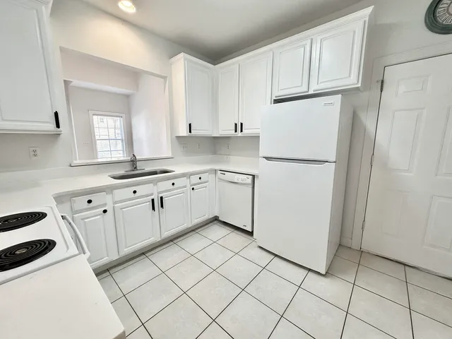 a kitchen with white cabinets and white appliances