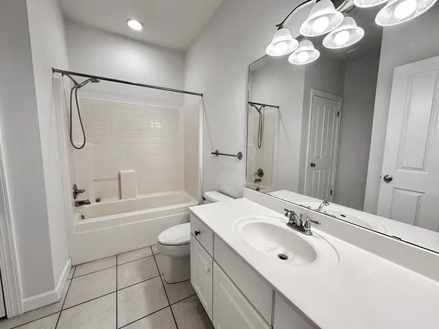 a bathroom with a sink a toilet a mirror a bathtub and shower