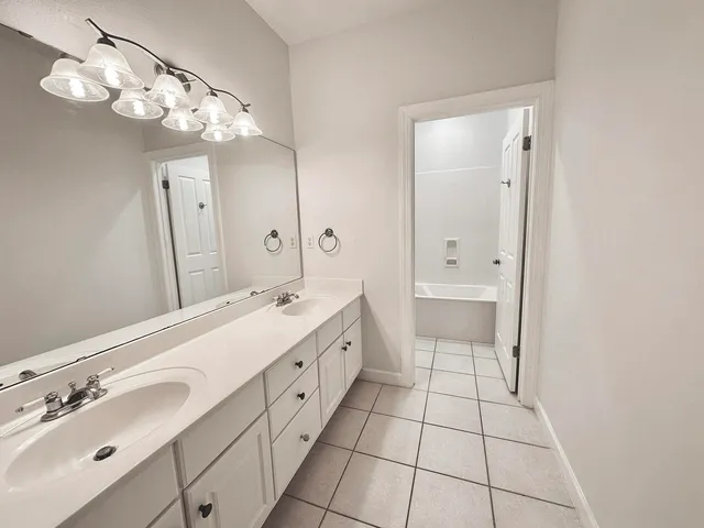 a spacious bathroom with a double vanity sink mirror and a toilet
