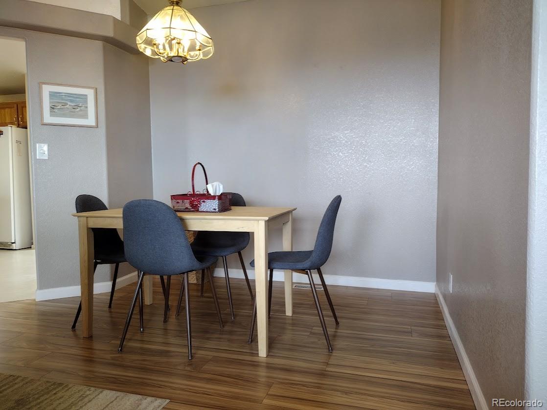 10421 West Lane Rye, CO 81069 - Photo 7 of 34 a dining room with furniture a chandelier and wooden floor