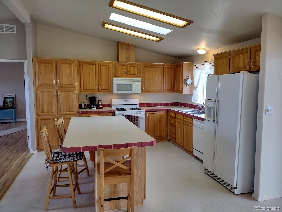 10421 West Lane Rye, CO 81069 - Photo 9 of 34 a kitchen with refrigerator cabinets and wooden table