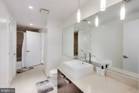 a bathroom with a sink a toilet a mirror and shower