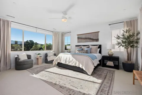 a bedroom with furniture and a large window