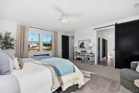 a bedroom with a bed large mirror and furniture