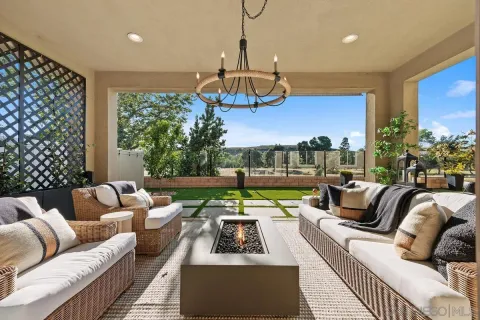 a living room with furniture a chandelier and a floor to ceiling window