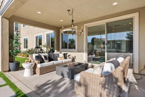 a living room with patio furniture and a chandelier