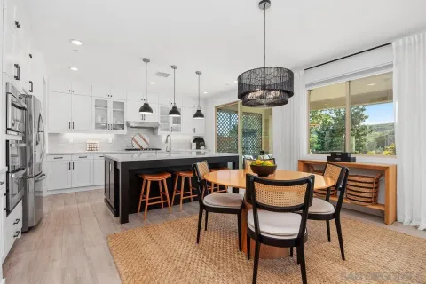 a dining room filled chandelier and wooden floor