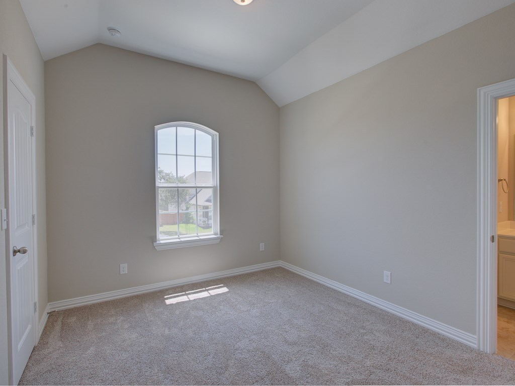 4303 Logan Ridge Drive Cedar Park, TX 78613 - Photo 14 of 24 Carpeted room featuring a vaulted ceiling and an arched window