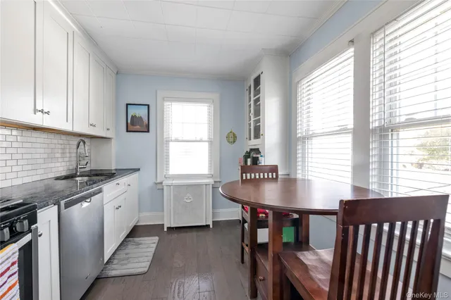 a kitchen that has a table chairs in it wooden floor and a window