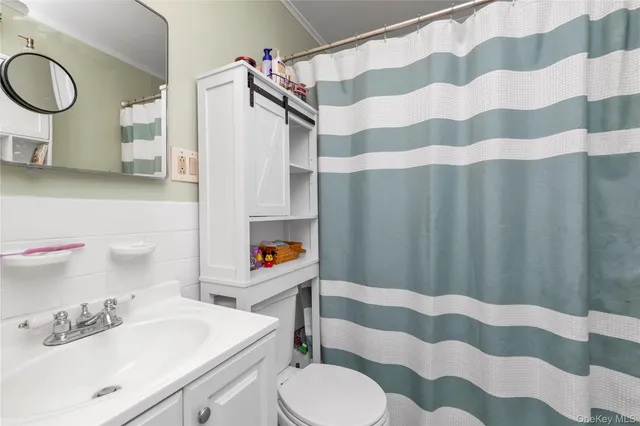 a bathroom with a sink a toilet and a mirror