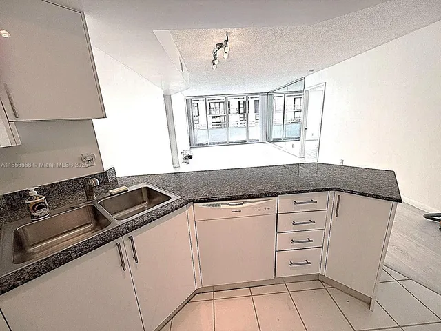 a kitchen with granite countertop white cabinets and appliances