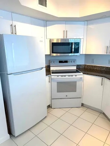 a kitchen with a stove top oven and refrigerator