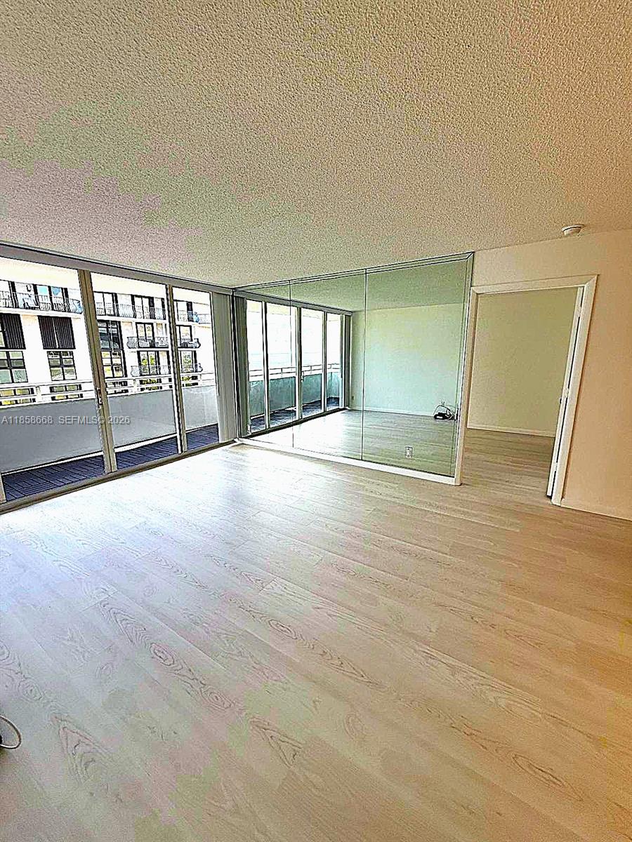 8911 Collins Avenue, Unit 1004 Surfside, FL 33154 - Photo 22 of 38 wooden floor in an empty room with a window