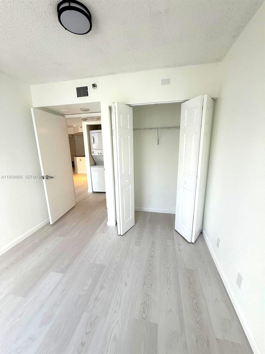 8911 Collins Avenue, Unit 1004 Surfside, FL 33154 - Photo 30 of 38 a view of empty room with wooden floor