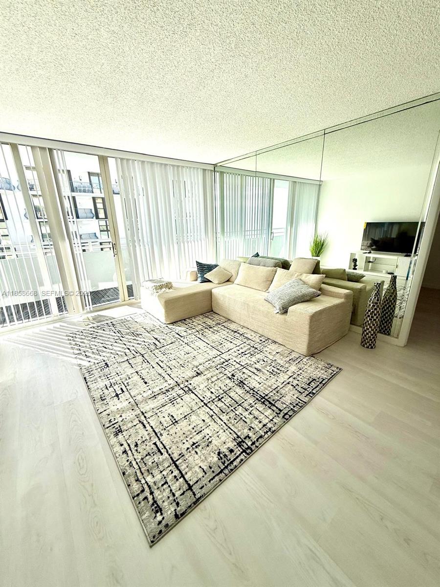 8911 Collins Avenue, Unit 1004 Surfside, FL 33154 - Photo 34 of 38 a living room with couch