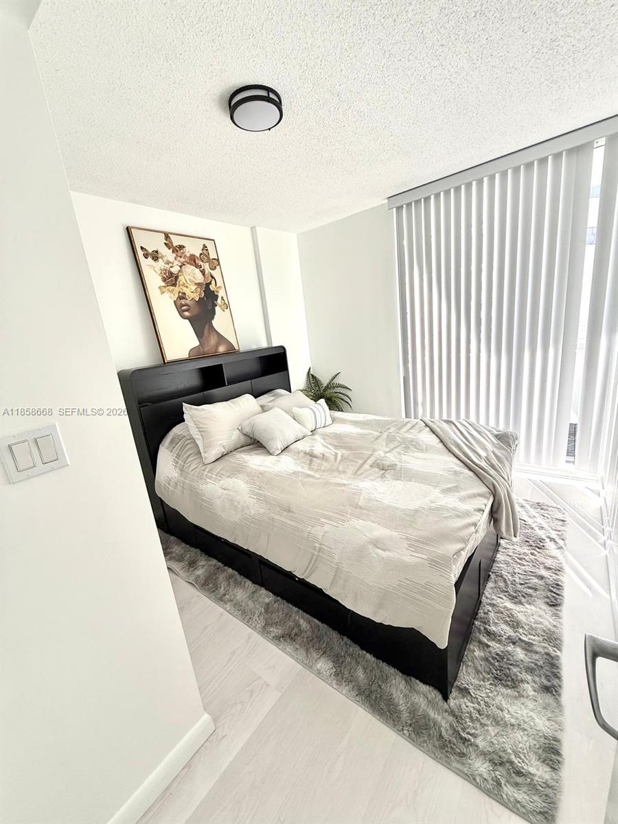 8911 Collins Avenue, Unit 1004 Surfside, FL 33154 - Photo 37 of 38 a bedroom with a bed and a window