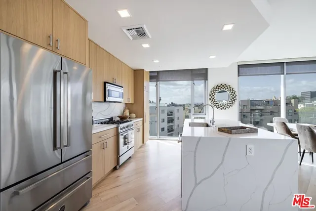 a kitchen with stainless steel appliances granite countertop a refrigerator sink and stove