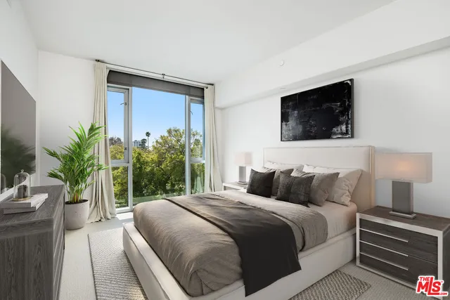 a bedroom with a large bed and a potted plant
