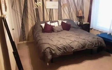 a bedroom with a bed a window and tub