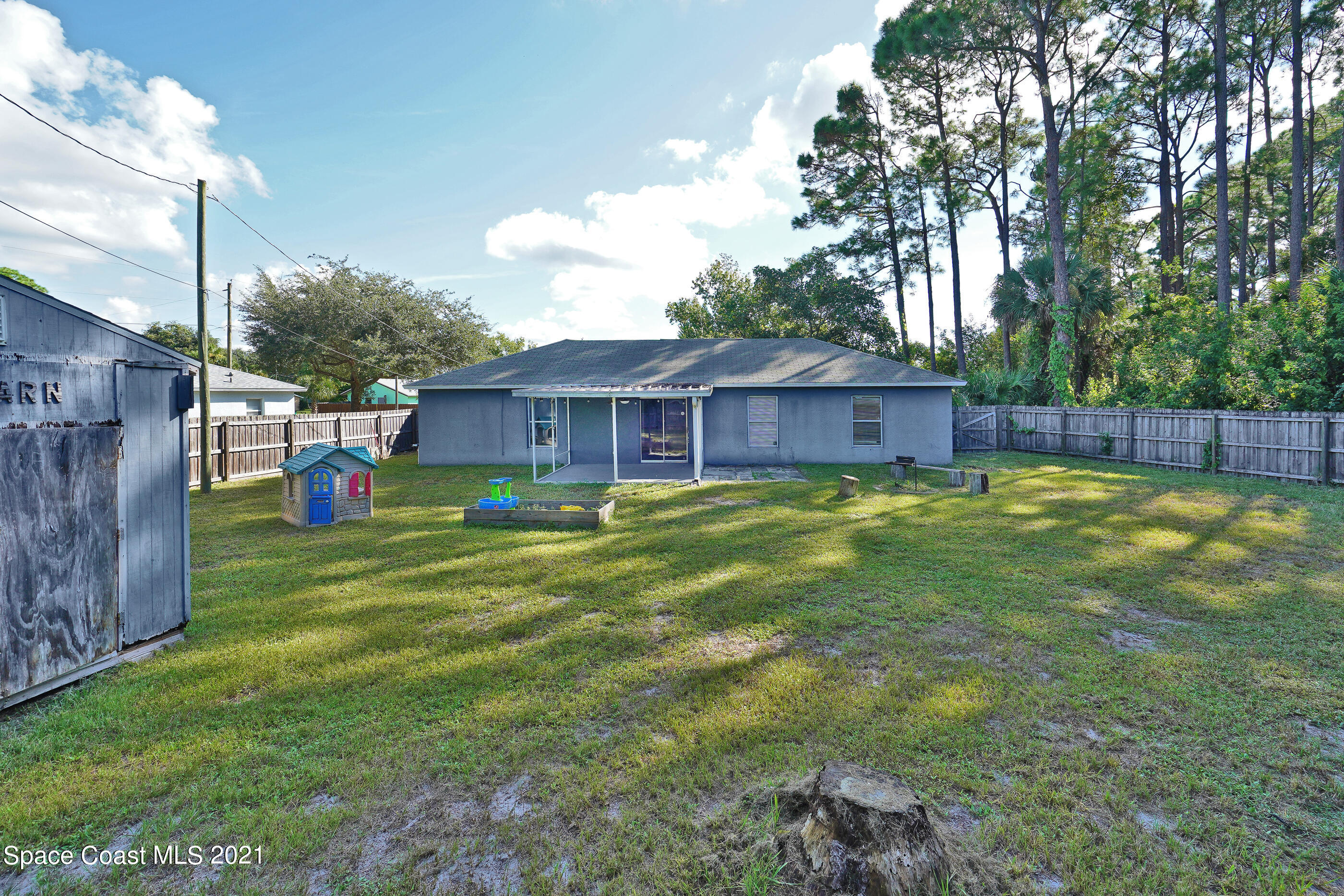 905 Macco Road Cocoa, FL 32927 - Photo 20 of 27 a view of a house with a backyard and a patio