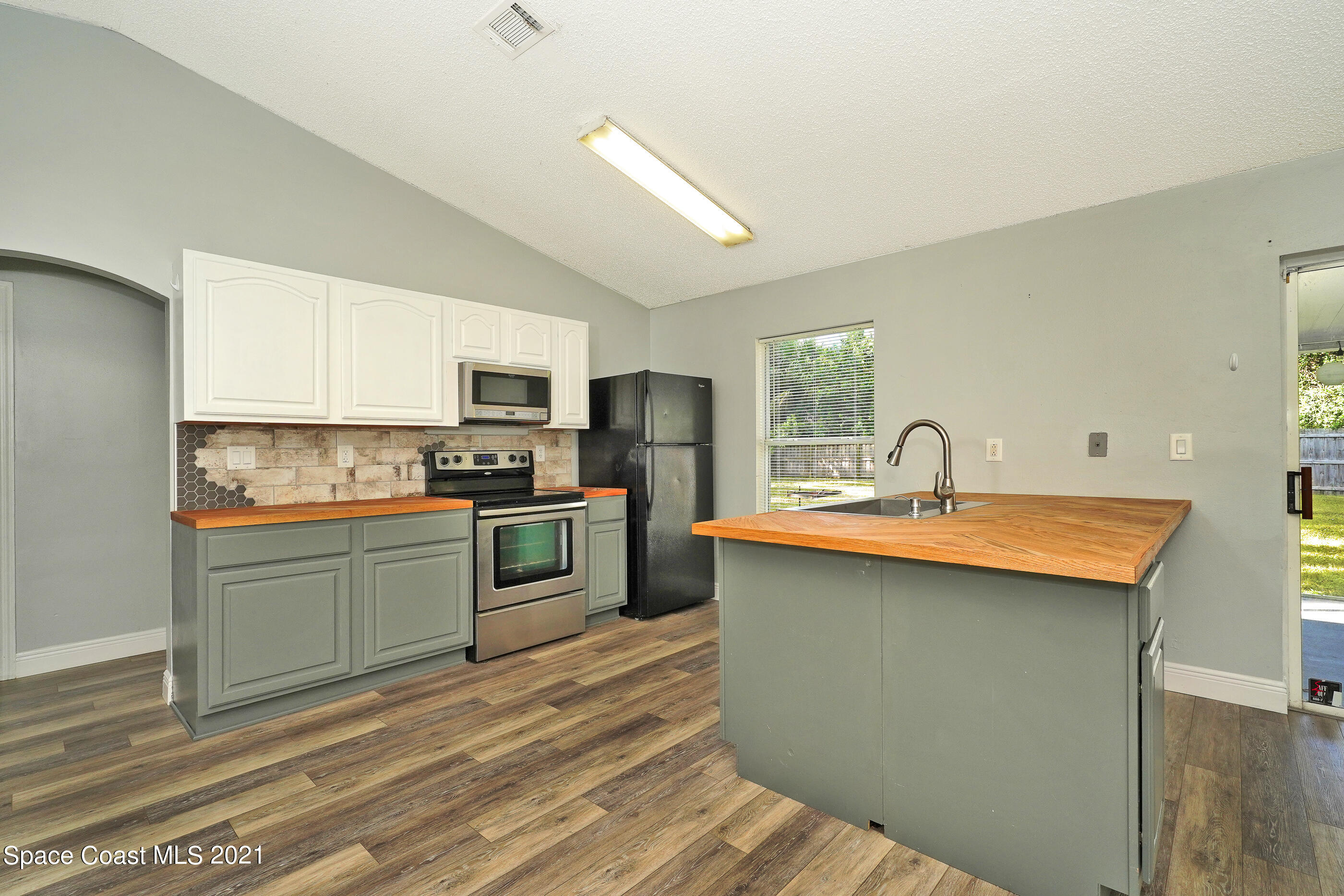 905 Macco Road Cocoa, FL 32927 - Photo 7 of 27 a kitchen with stainless steel appliances granite countertop a sink stove refrigerator and microwave