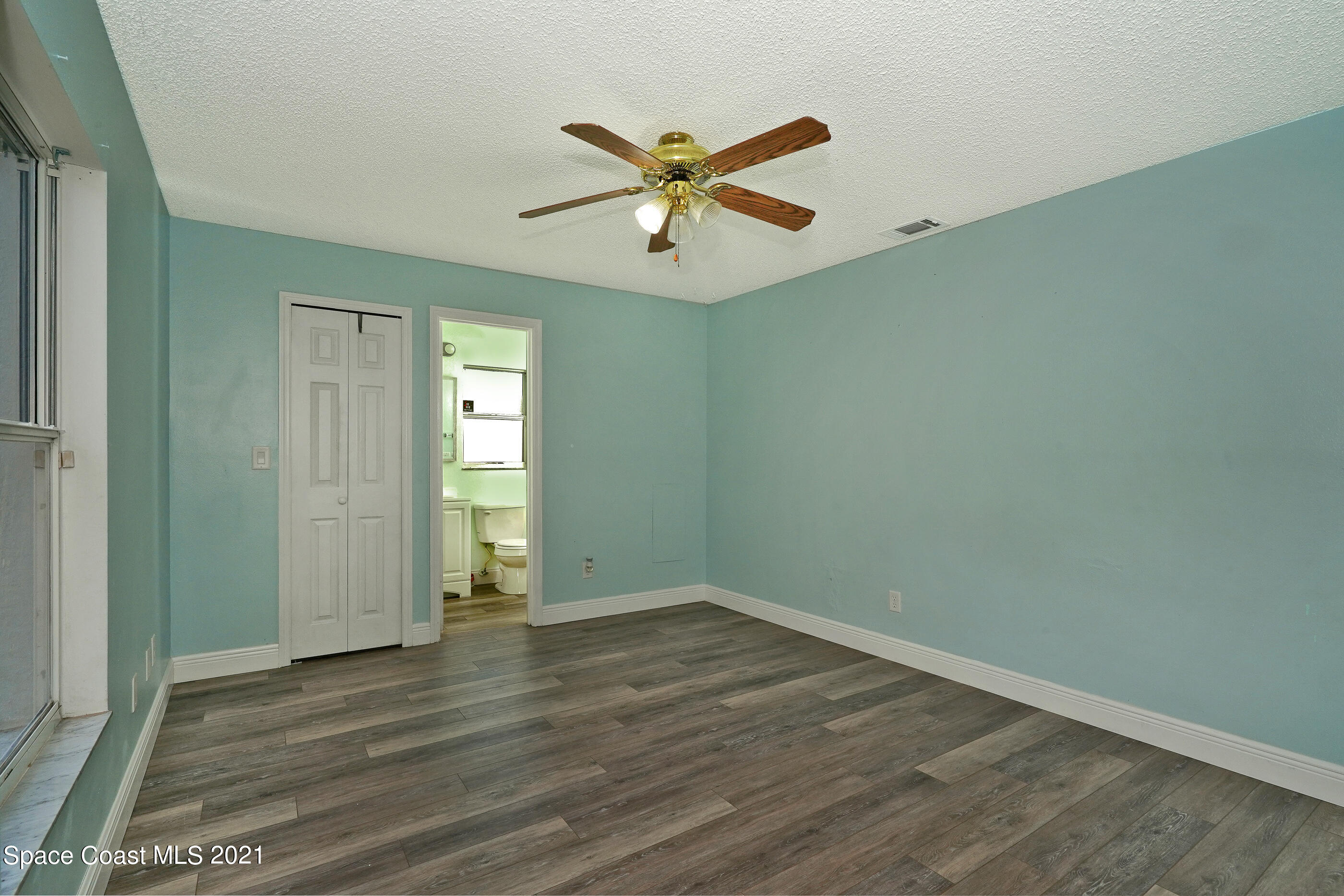 905 Macco Road Cocoa, FL 32927 - Photo 10 of 27 an empty room with wooden floor and windows