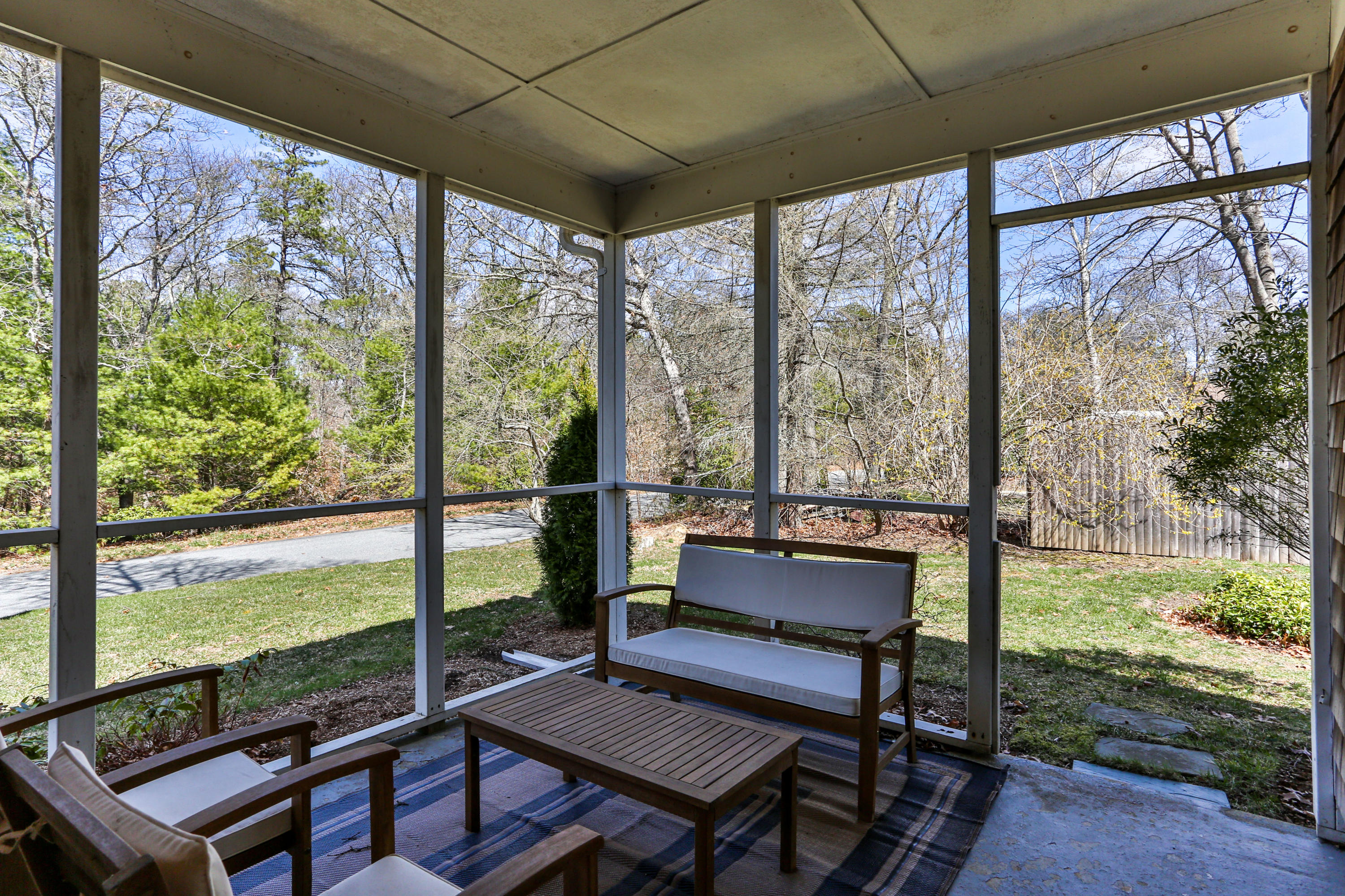 36 Scituate Road Mashpee, MA 02649 - Photo 34 of 36 a living room with large trees and a table
