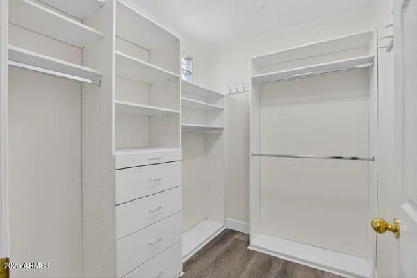 a view of walk in closet with empty racks