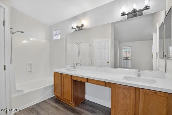 a bathroom with a tub sink and mirror