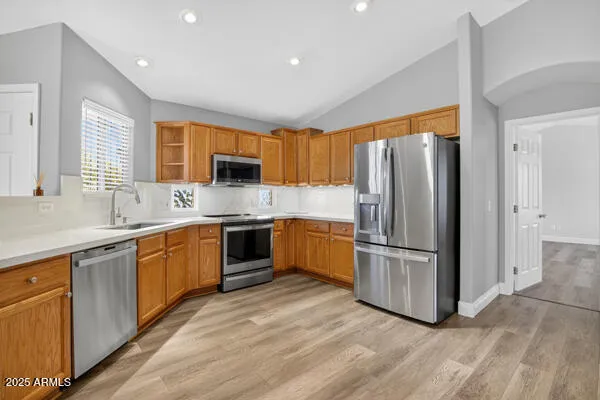 a kitchen with stainless steel appliances granite countertop a refrigerator stove and sink