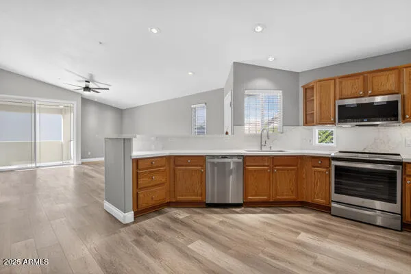 a kitchen with granite countertop a stove a sink and a microwave