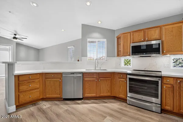 a kitchen with stainless steel appliances granite countertop a stove top oven a sink dishwasher and a microwave oven with cabinets